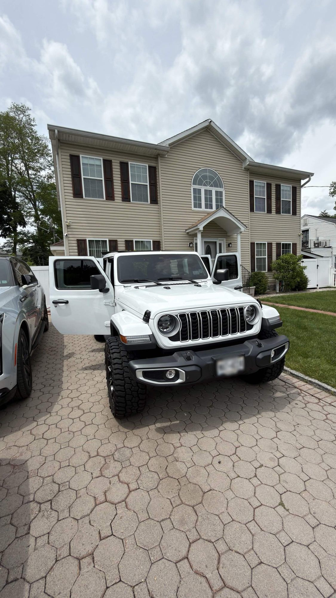 Freshly detailed white Jeep Wrangler in a Westchester driveway